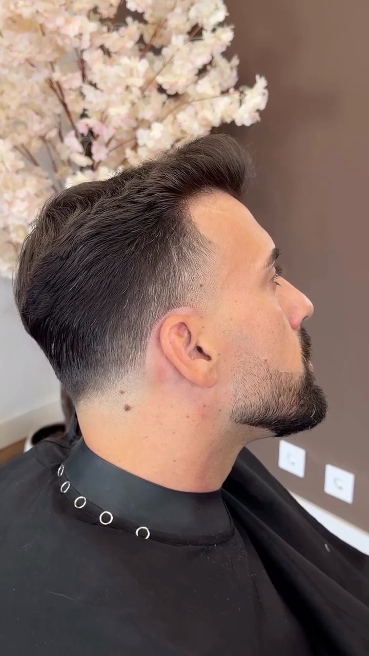 Perfil de um cliente com corte degradê e barba desenhada à lâmina